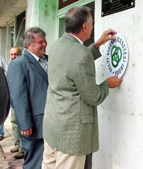 Dr_Csikai_Miklós_elhelyezi_az_iroda_logoját_a_bejáratnál.jpg Dr_Csikai_Miklós_elhelyezi_az_iroda_logoját_a_bejáratnál.jpg