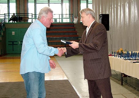Dr. Rébeli Szabó Tamás Bakos László tenisz edzőnek ad ajándékot.