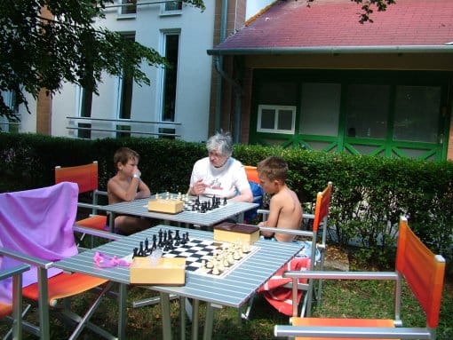 Táborozók sakkoznak a strand területén.